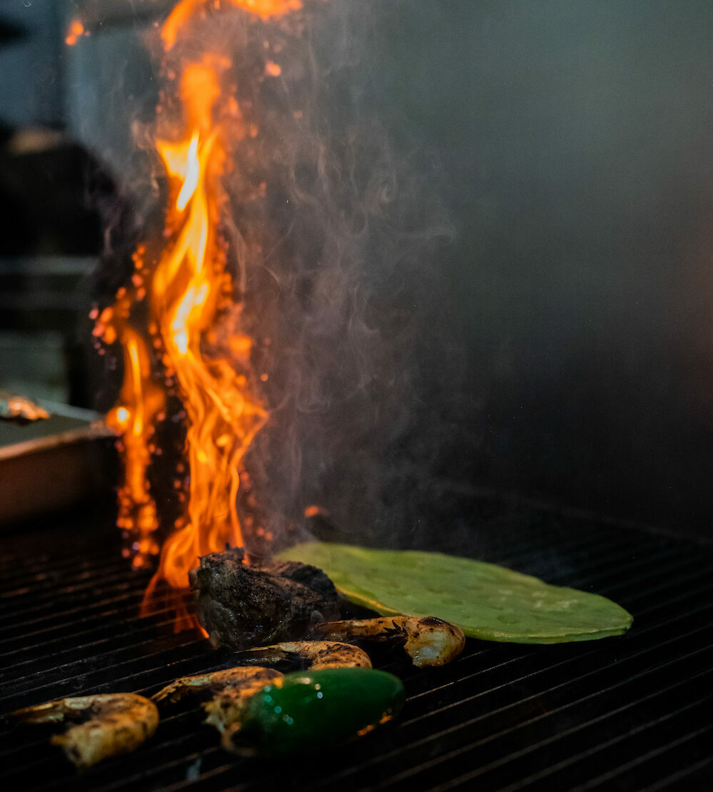 Flame roasting vegetables on a grill