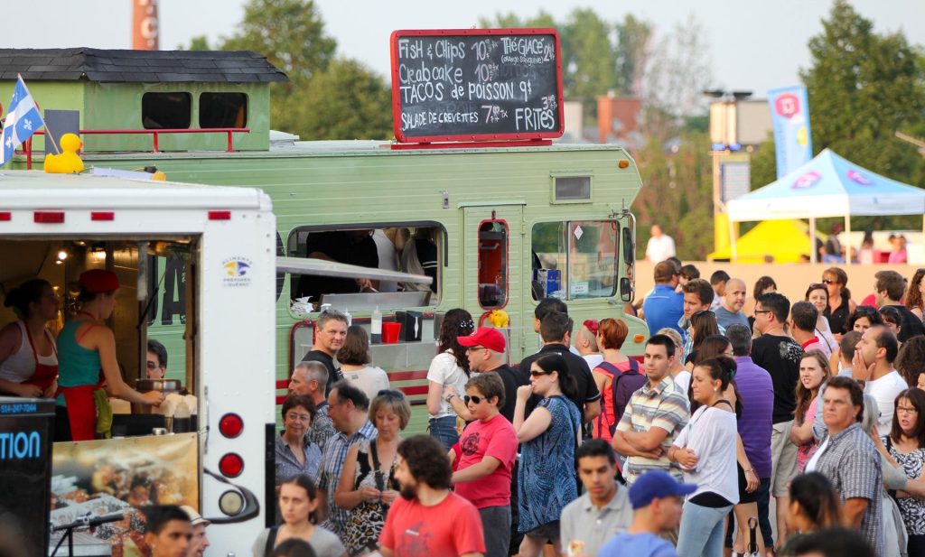 Crowd of people waiting in lines for food trucks