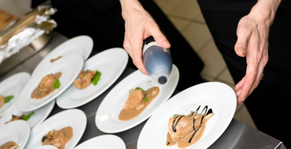 A chef plating final flourishes to several entrees before serving to illustrate how long does it take to be a chef.