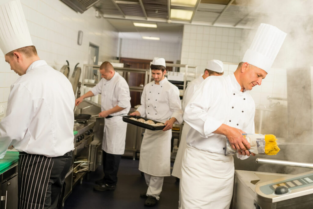 A variety of chefs at work in a kitchen to illustrate how much do chefs make.