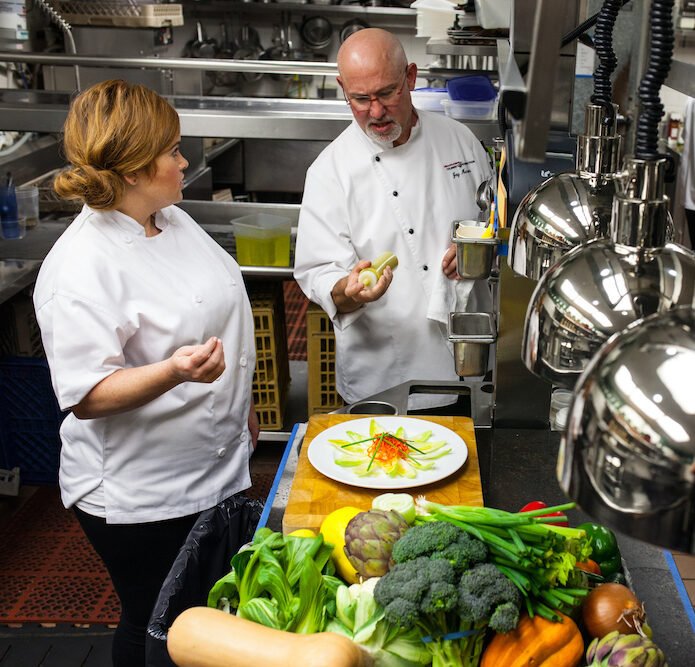 Chef instructing a student on plating