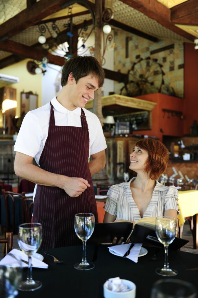 Male waiter waits on female patron.