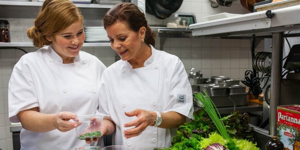 Chef showing a culinary student different herbs